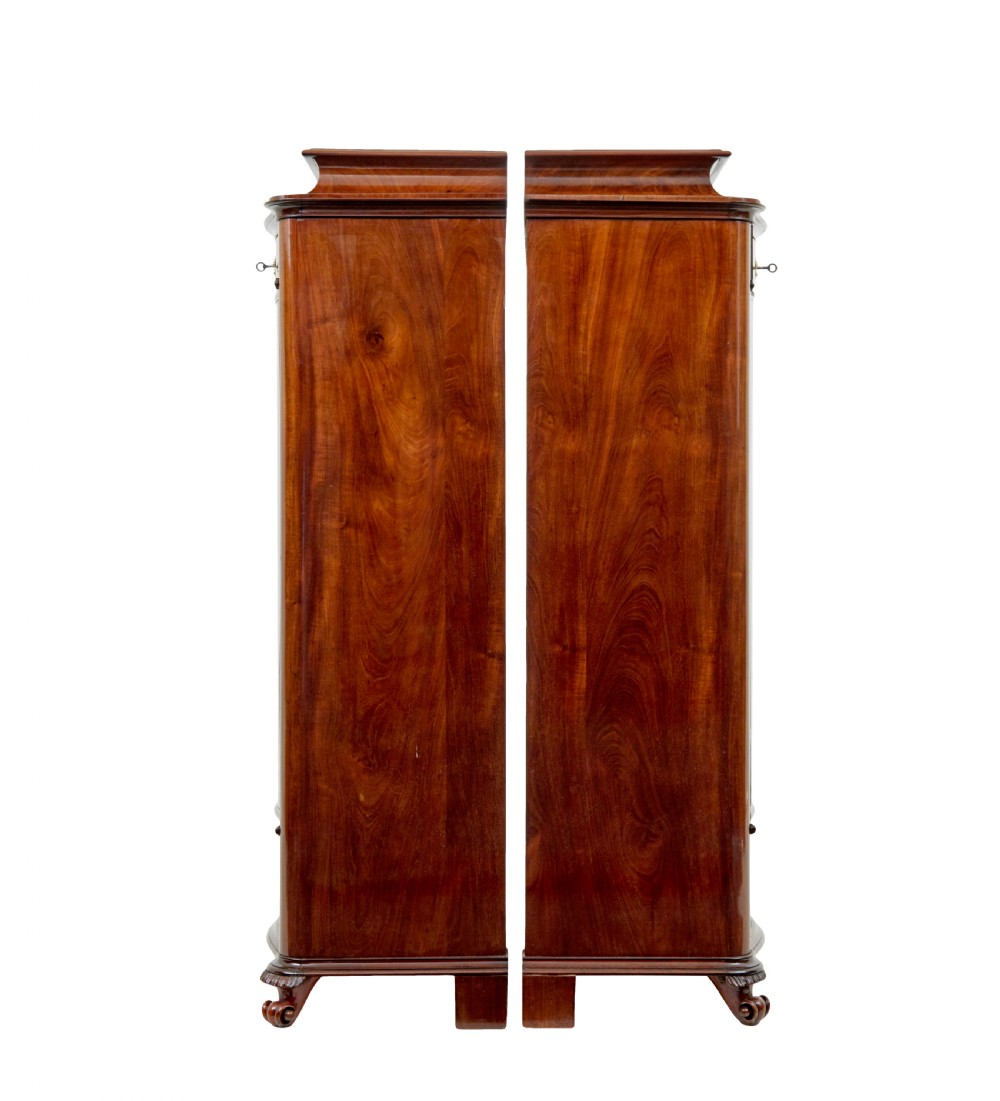 A pair of 19th-century Scandinavian tall mahogany cupboards featuring serpentine fronts, flame veneer panels, and ornate brass keyhole escutcheons. View IV