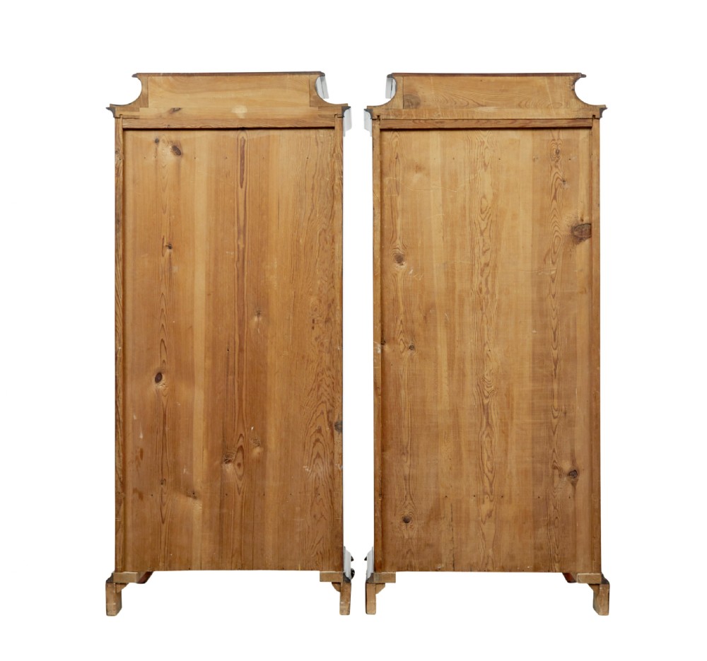 A pair of 19th-century Scandinavian tall mahogany cupboards featuring serpentine fronts, flame veneer panels, and ornate brass keyhole escutcheons. View V