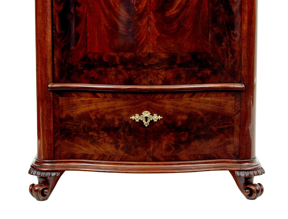 A pair of 19th-century Scandinavian tall mahogany cupboards featuring serpentine fronts, flame veneer panels, and ornate brass keyhole escutcheons. View VII