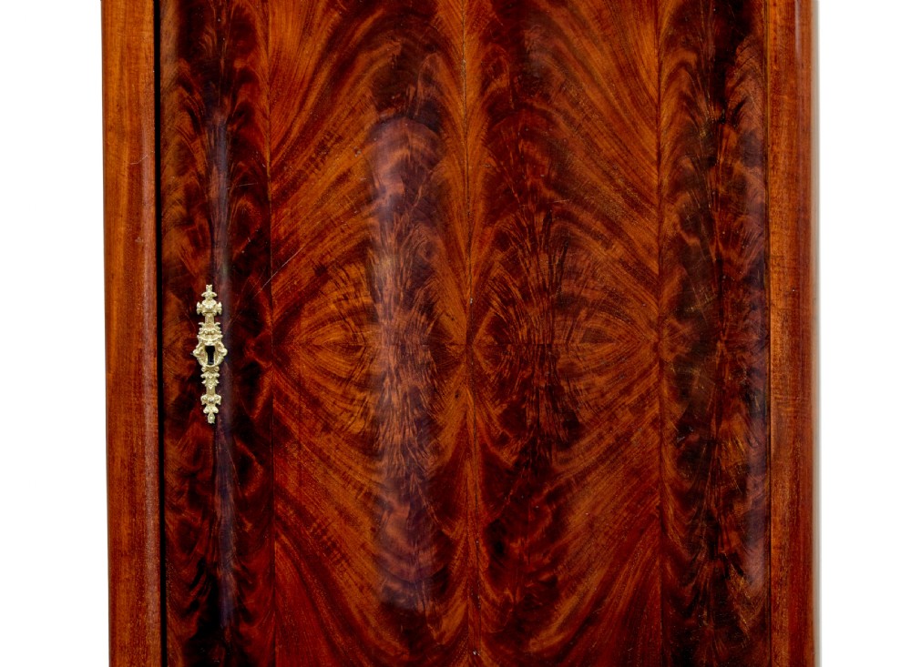 A pair of 19th-century Scandinavian tall mahogany cupboards featuring serpentine fronts, flame veneer panels, and ornate brass keyhole escutcheons. View VIII
