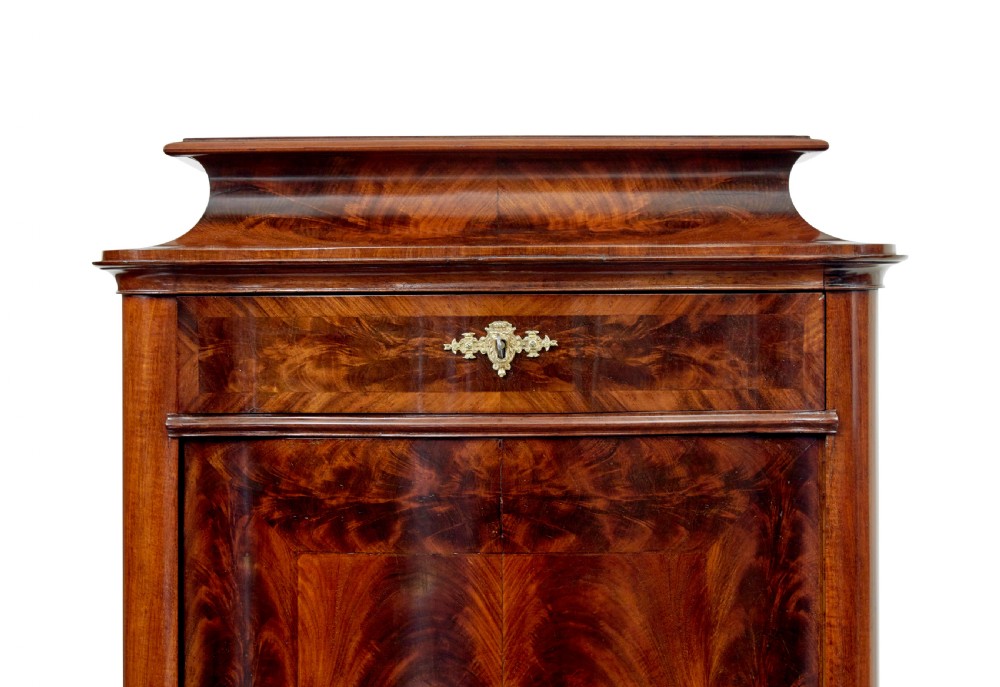 A pair of 19th-century Scandinavian tall mahogany cupboards featuring serpentine fronts, flame veneer panels, and ornate brass keyhole escutcheons. View IX