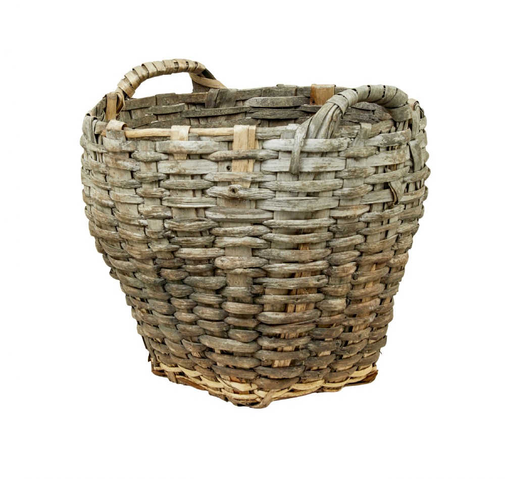 A large, weathered hand-woven basket made from thick grey pine splints with two integrated woven handles at the top rim.