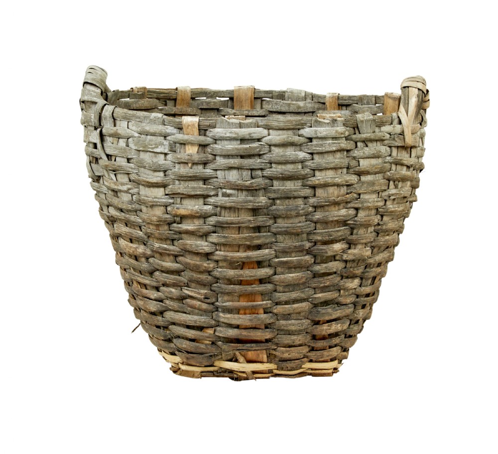 A large, weathered hand-woven basket made from thick grey pine splints with two integrated woven handles at the top rim. View V