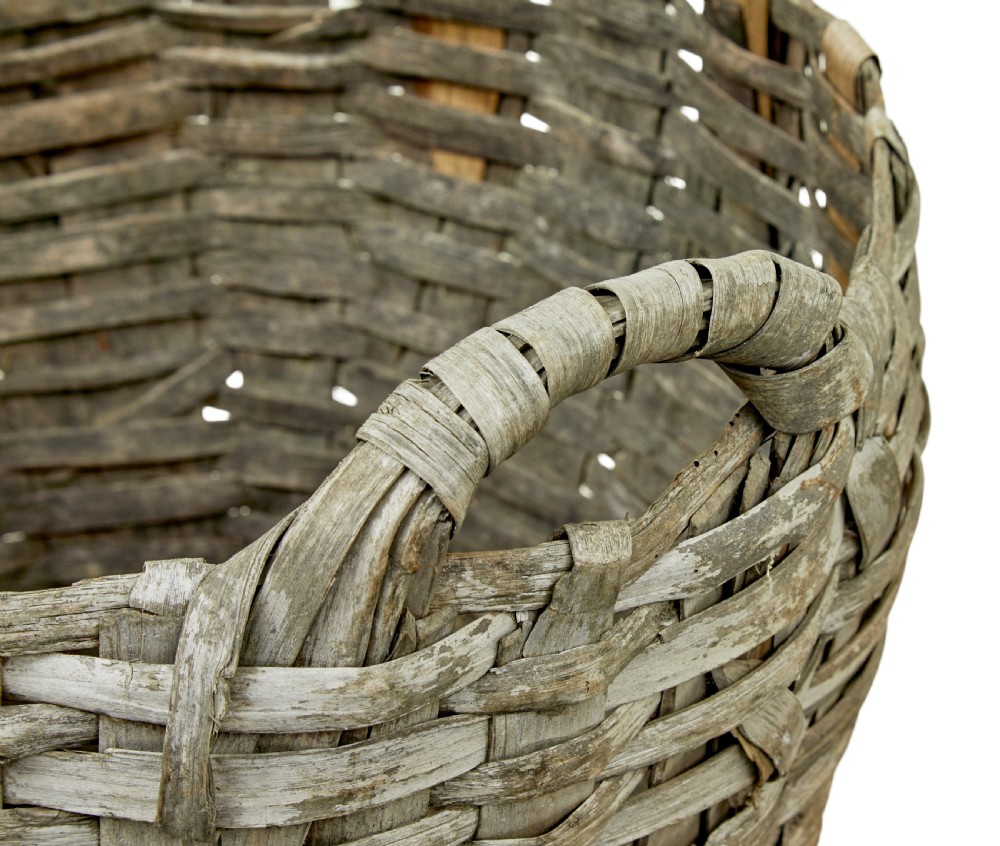 A large, weathered hand-woven basket made from thick grey pine splints with two integrated woven handles at the top rim. View VIII