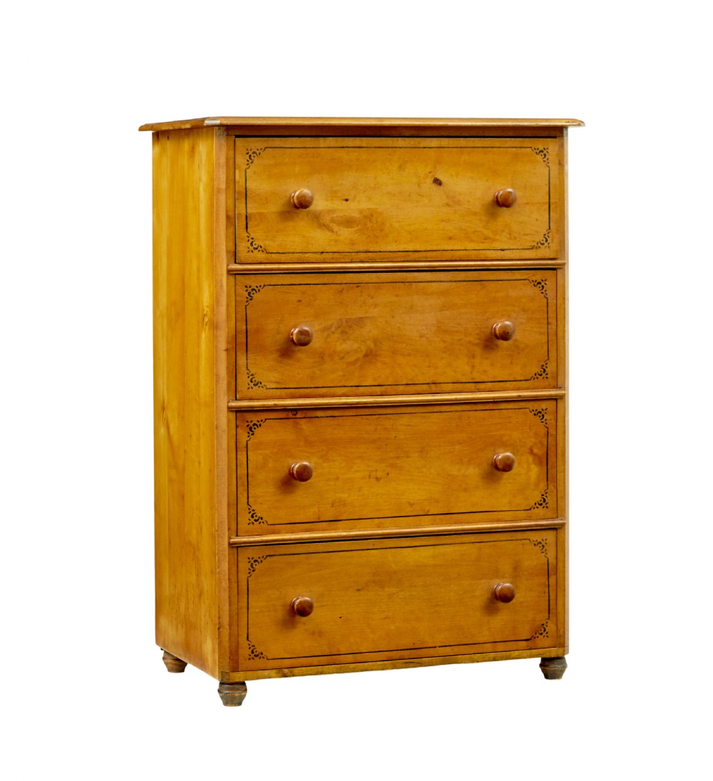A tall Swedish honey-coloured wooden chest of four drawers featuring hand-painted black corner flourishes and turned knobs.