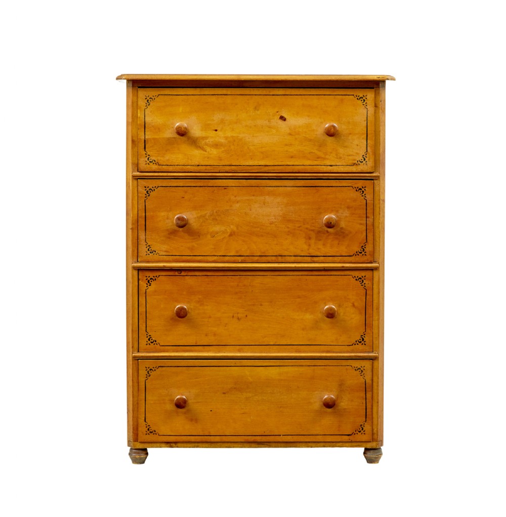 A tall Swedish honey-coloured wooden chest of four drawers featuring hand-painted black corner flourishes and turned knobs. View VI