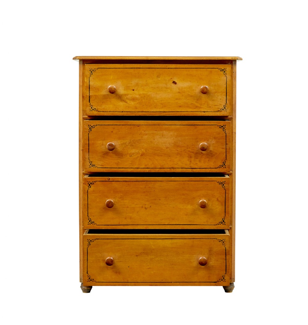 A tall Swedish honey-coloured wooden chest of four drawers featuring hand-painted black corner flourishes and turned knobs. View VIII