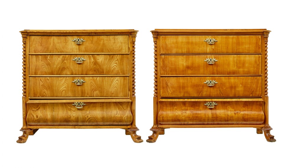 A matching pair of mid-19th-century Swedish carved elm chests of drawers featuring four drawers, barley twist side columns, carved paw feet, and brass hardware.