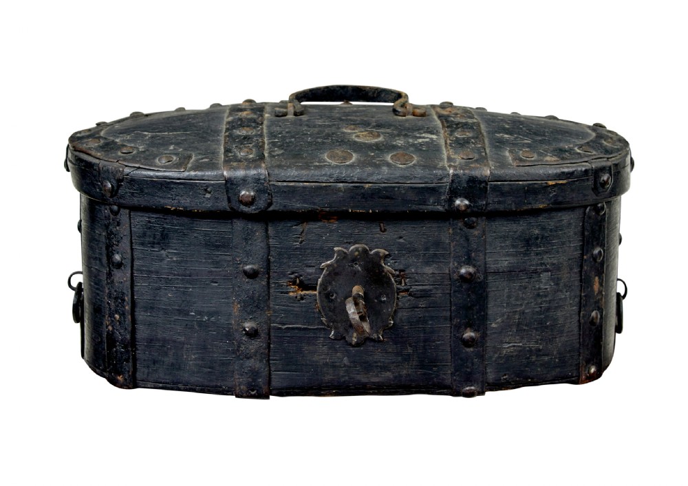 A 19th-century oval black-painted pine box featuring heavy iron straps, rivets, a top handle, and a decorative keyhole escutcheon.