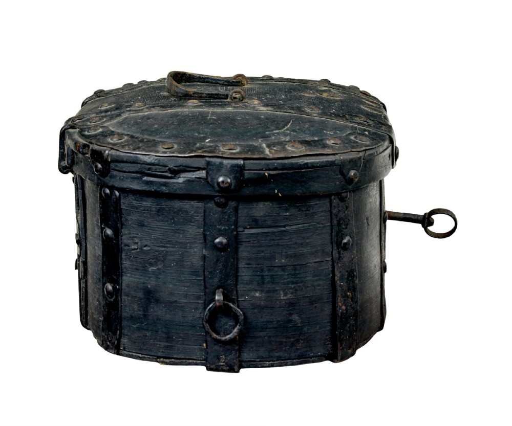 A 19th-century oval black-painted pine box featuring heavy iron straps, rivets, a top handle, and a decorative keyhole escutcheon. View V