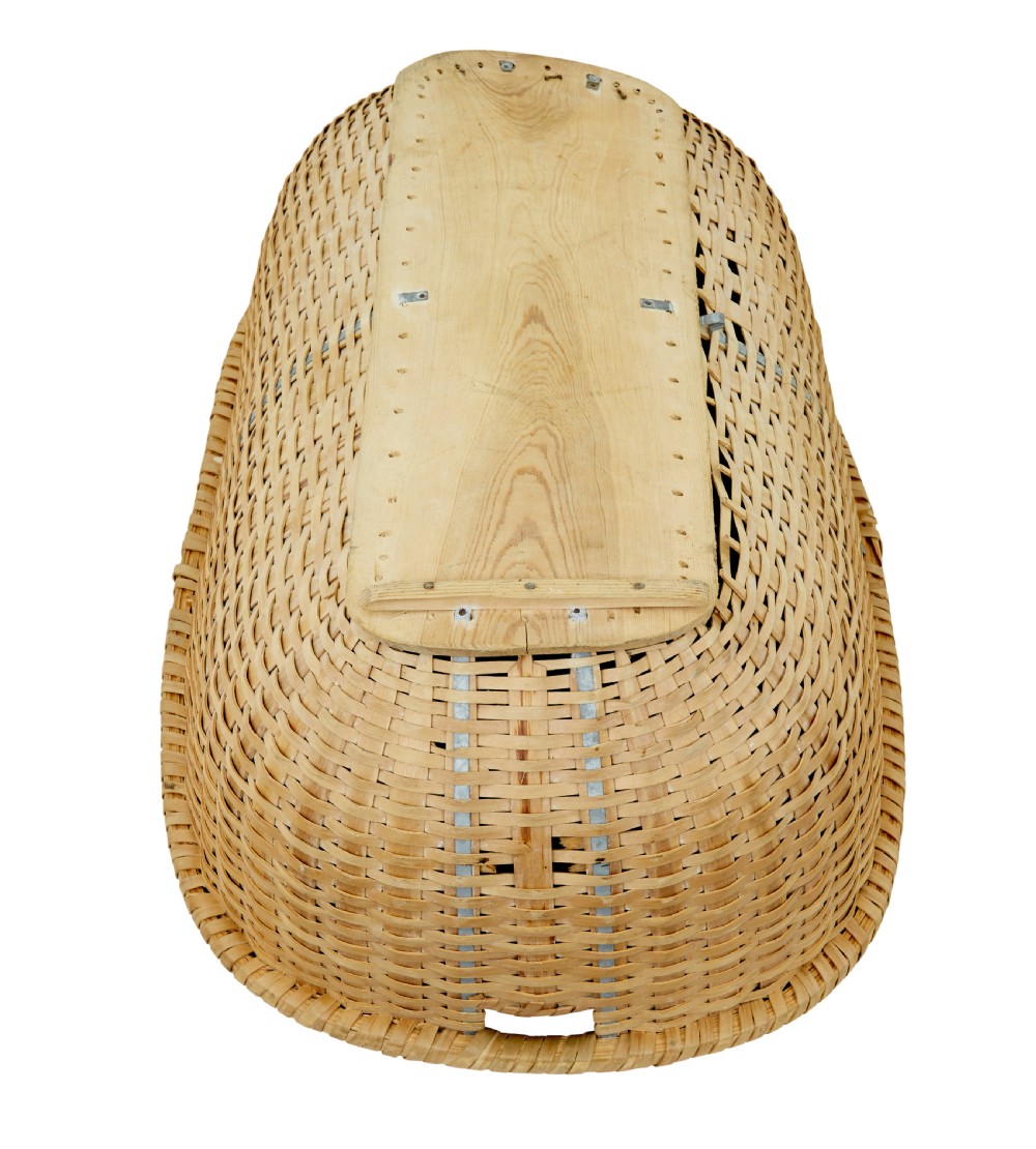 A large oval hand-woven pine basket with integrated handles and a reinforced wooden base. View V