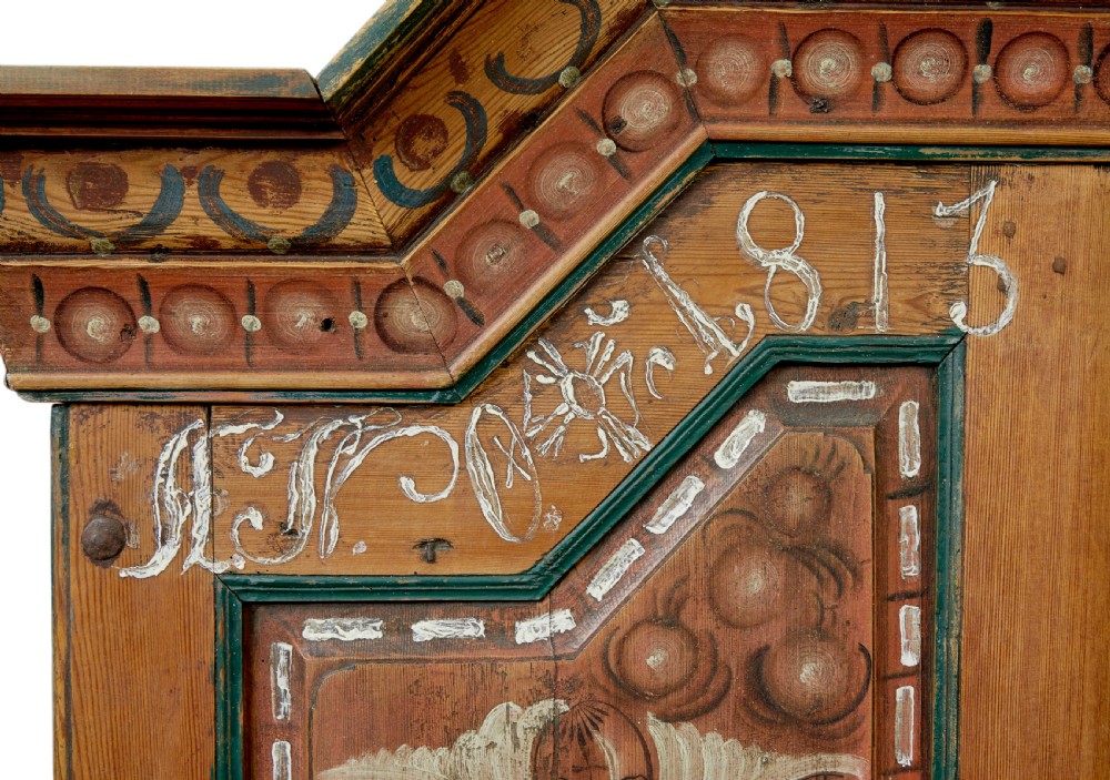 An early nineteenth-century Swedish painted pine cupboard featuring a shaped upper section with painted panel doors dated 1813 above an open shelf and lower cabinet. View VIII