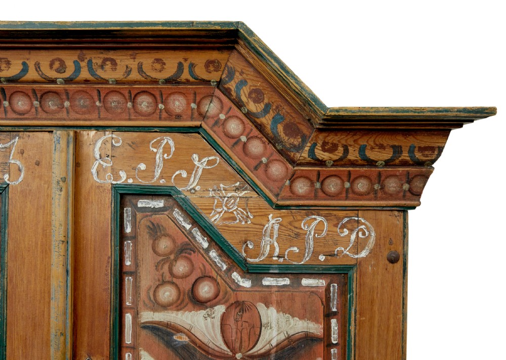 An early nineteenth-century Swedish painted pine cupboard featuring a shaped upper section with painted panel doors dated 1813 above an open shelf and lower cabinet. View IX