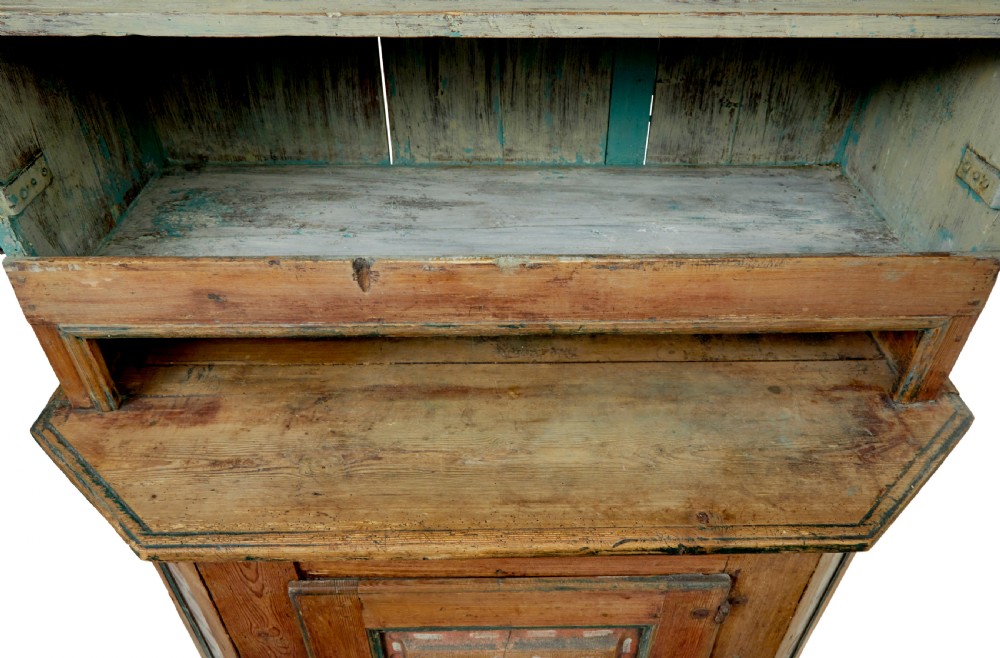 An early nineteenth-century Swedish painted pine cupboard featuring a shaped upper section with painted panel doors dated 1813 above an open shelf and lower cabinet. View XI