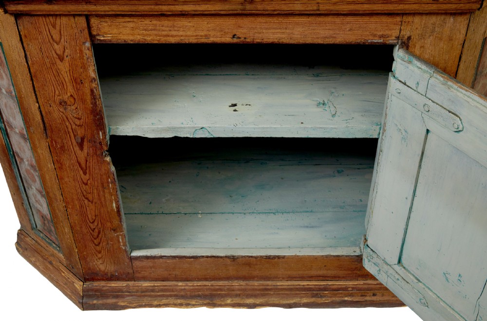 An early nineteenth-century Swedish painted pine cupboard featuring a shaped upper section with painted panel doors dated 1813 above an open shelf and lower cabinet. View XII