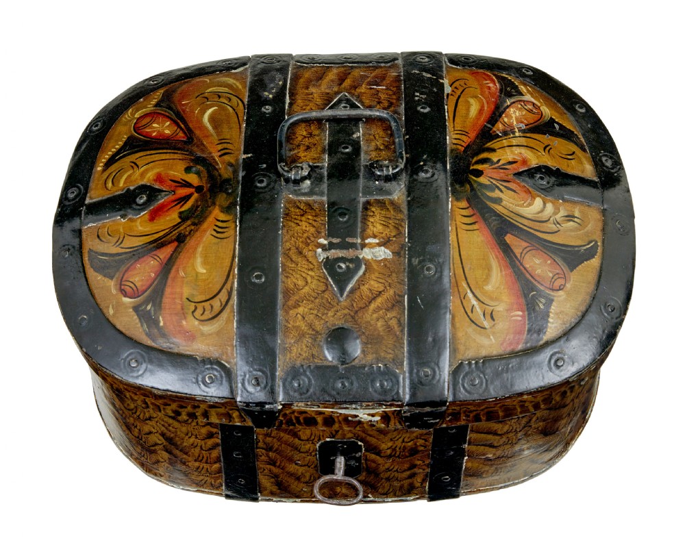 An oval 19th-century Scandinavian painted wooden box featuring black iron straps, a top metal handle, comb-painted sides, and hand-painted floral motifs on the curved lid. View V