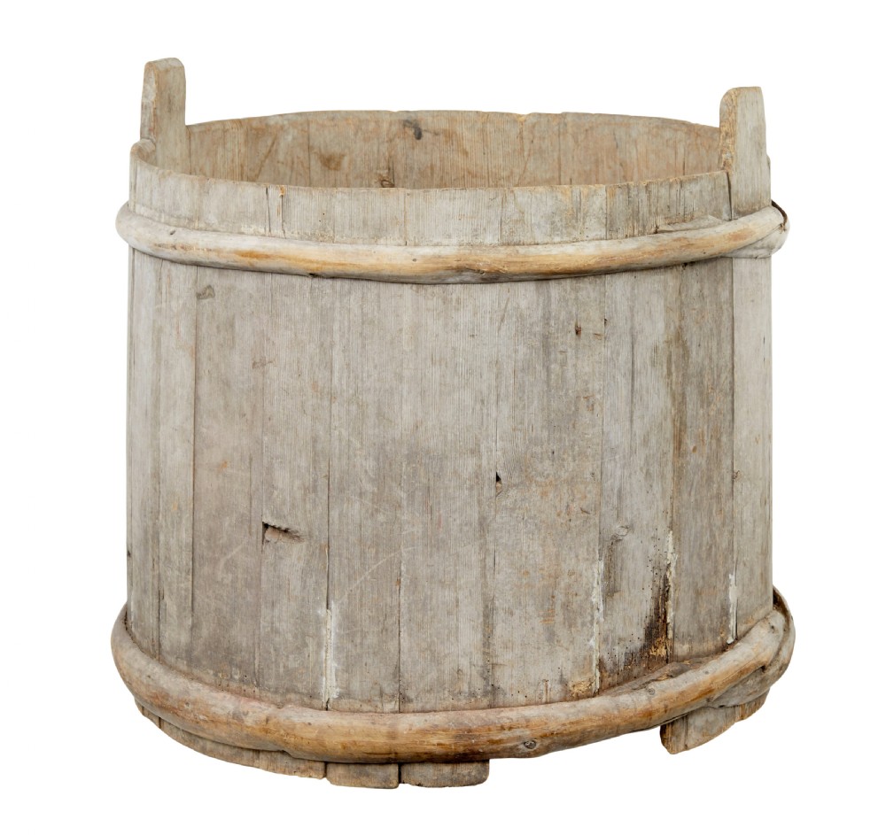 A large round 19th-century Scandinavian pine storage barrel featuring vertical stave timber construction and thick wooden binding hoops around the top and bottom.