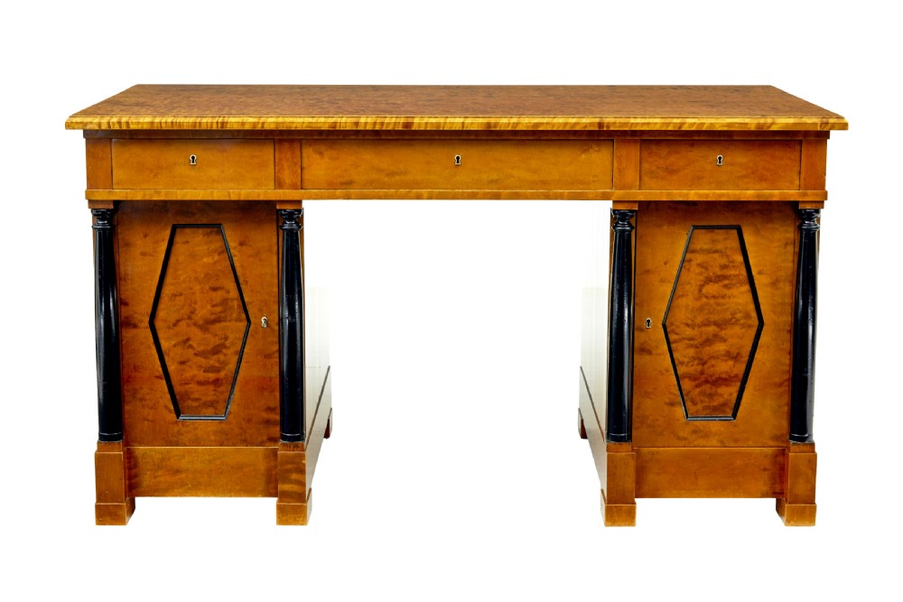 A Swedish Empire Revival pedestal desk crafted from golden flame birch veneer featuring three frieze drawers, ebonised column accents, and geometric inlaid cabinet doors. View II