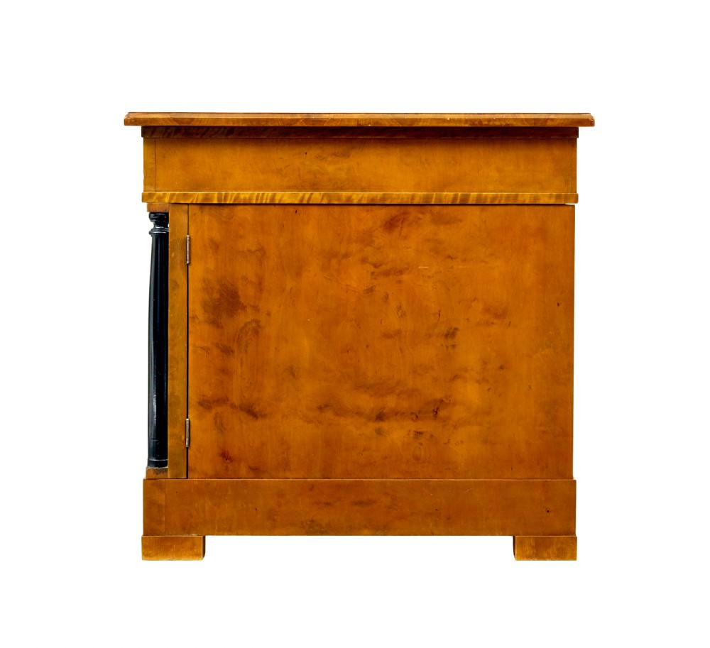 A Swedish Empire Revival pedestal desk crafted from golden flame birch veneer featuring three frieze drawers, ebonised column accents, and geometric inlaid cabinet doors. View IV