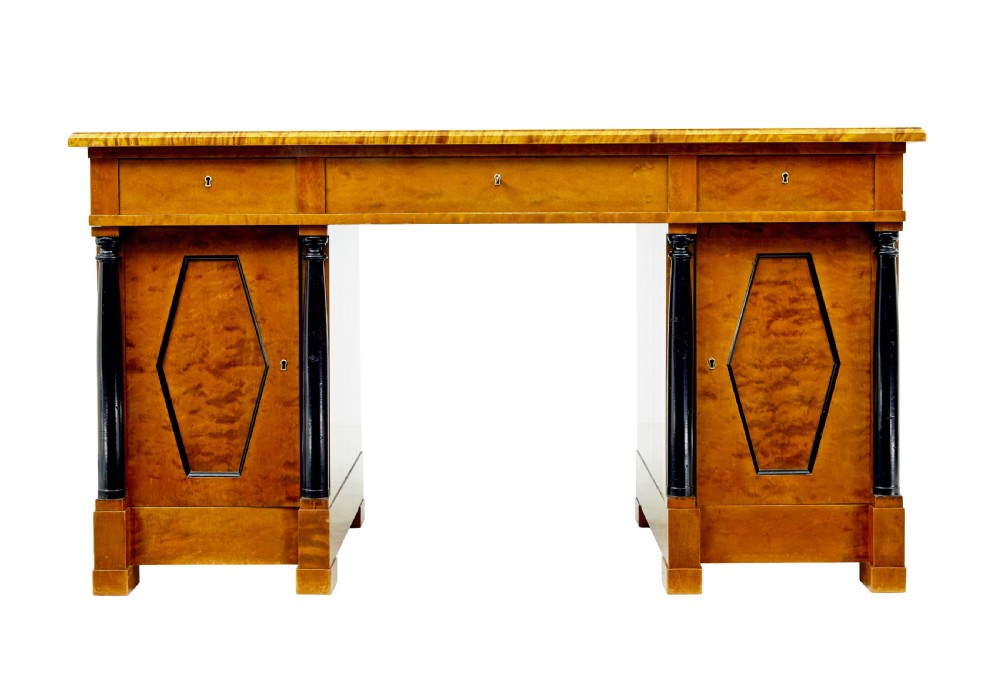 A Swedish Empire Revival pedestal desk crafted from golden flame birch veneer featuring three frieze drawers, ebonised column accents, and geometric inlaid cabinet doors. View VII