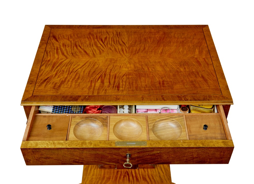A late nineteenth-century warm golden birch sewing table featuring a single drawer with a brass keyhole, supported by a lyre-shaped pedestal on a plinth base with bun feet. View V