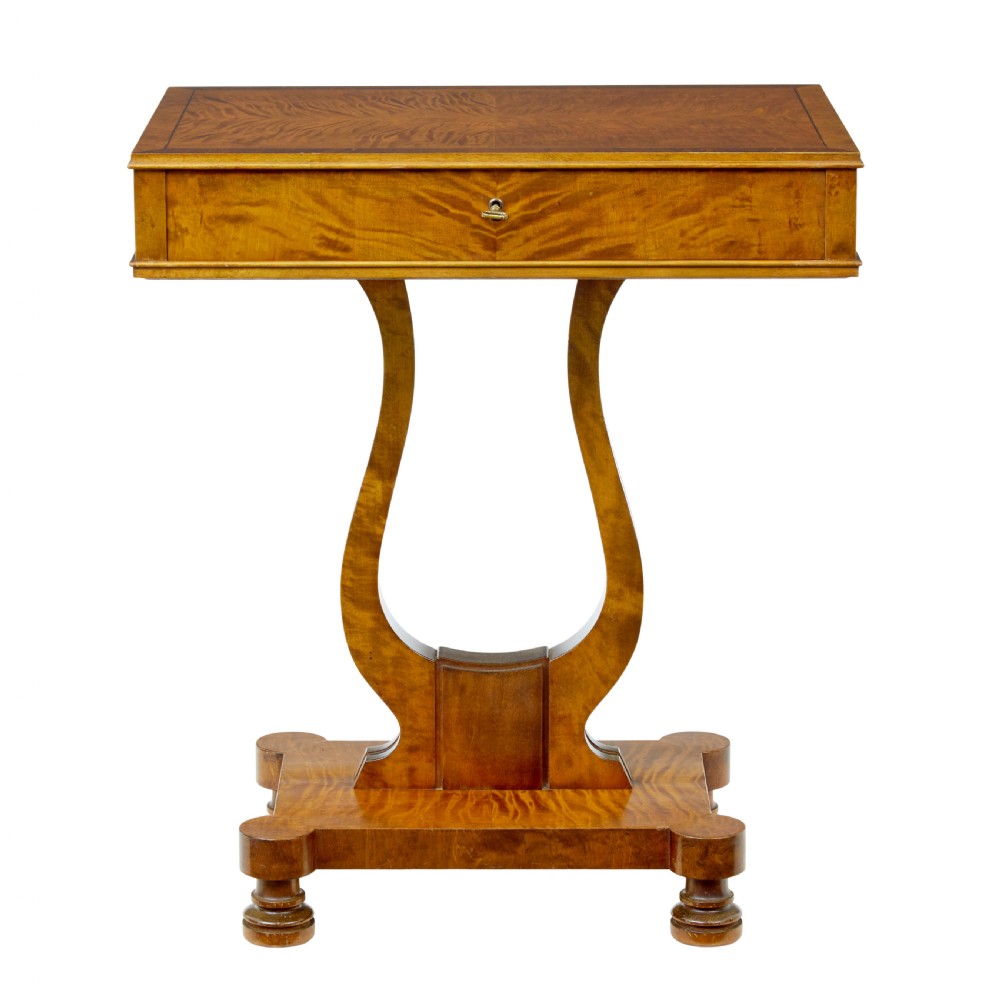 A late nineteenth-century warm golden birch sewing table featuring a single drawer with a brass keyhole, supported by a lyre-shaped pedestal on a plinth base with bun feet. View VII
