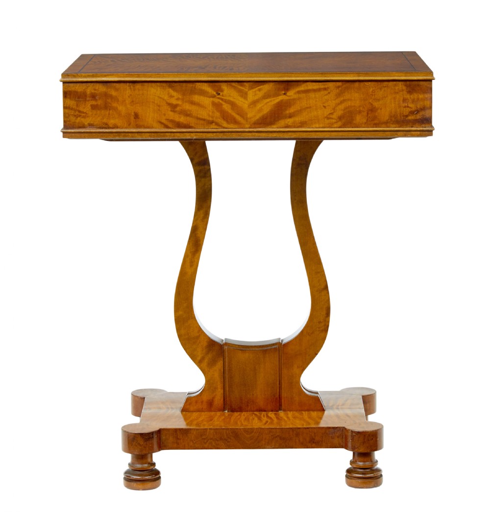 A late nineteenth-century warm golden birch sewing table featuring a single drawer with a brass keyhole, supported by a lyre-shaped pedestal on a plinth base with bun feet. View IX