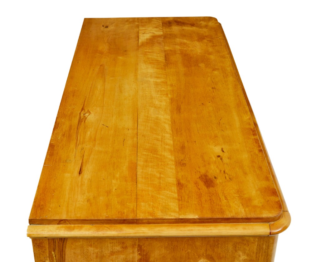 A nineteenth-century Scandinavian chest of drawers crafted from golden birch with four wide drawers and keyhole escutcheons. View II