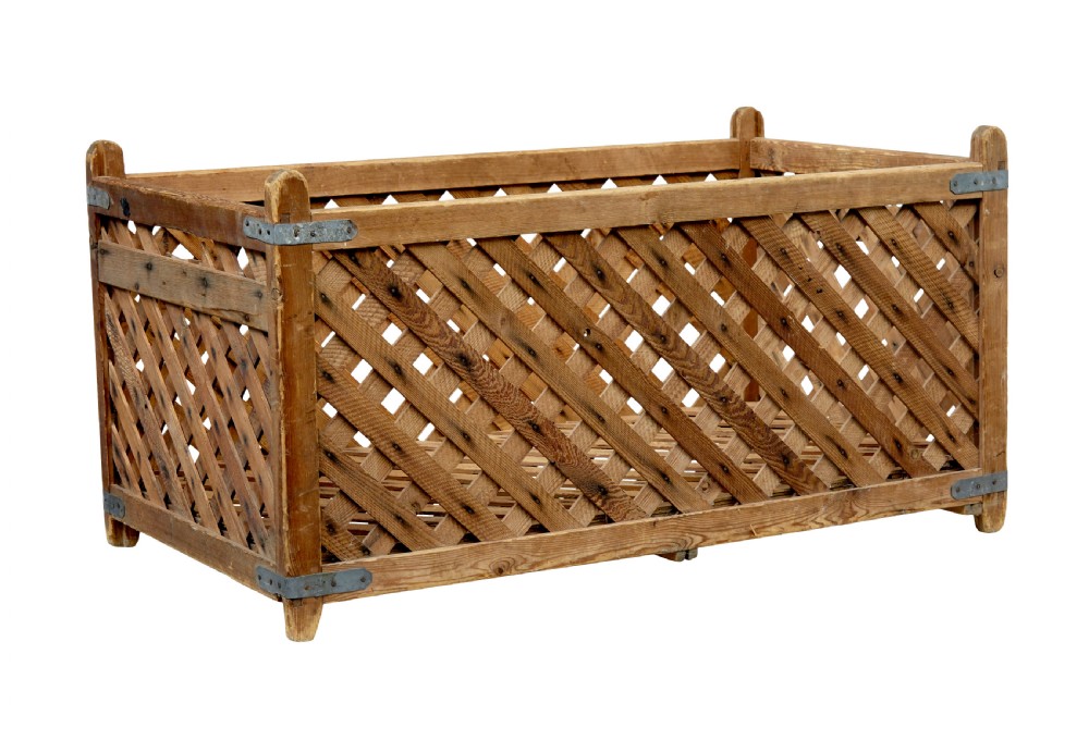A rectangular 19th-century Scandinavian pine log basket with diagonal lattice side panels and iron corner braces.