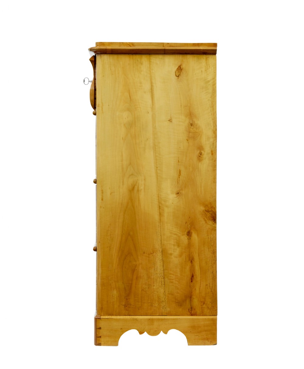 A 19th-century Swedish chest of drawers constructed from honey-toned flame birch with four drawers, keyhole escutcheons, and a scalloped base apron. View VII