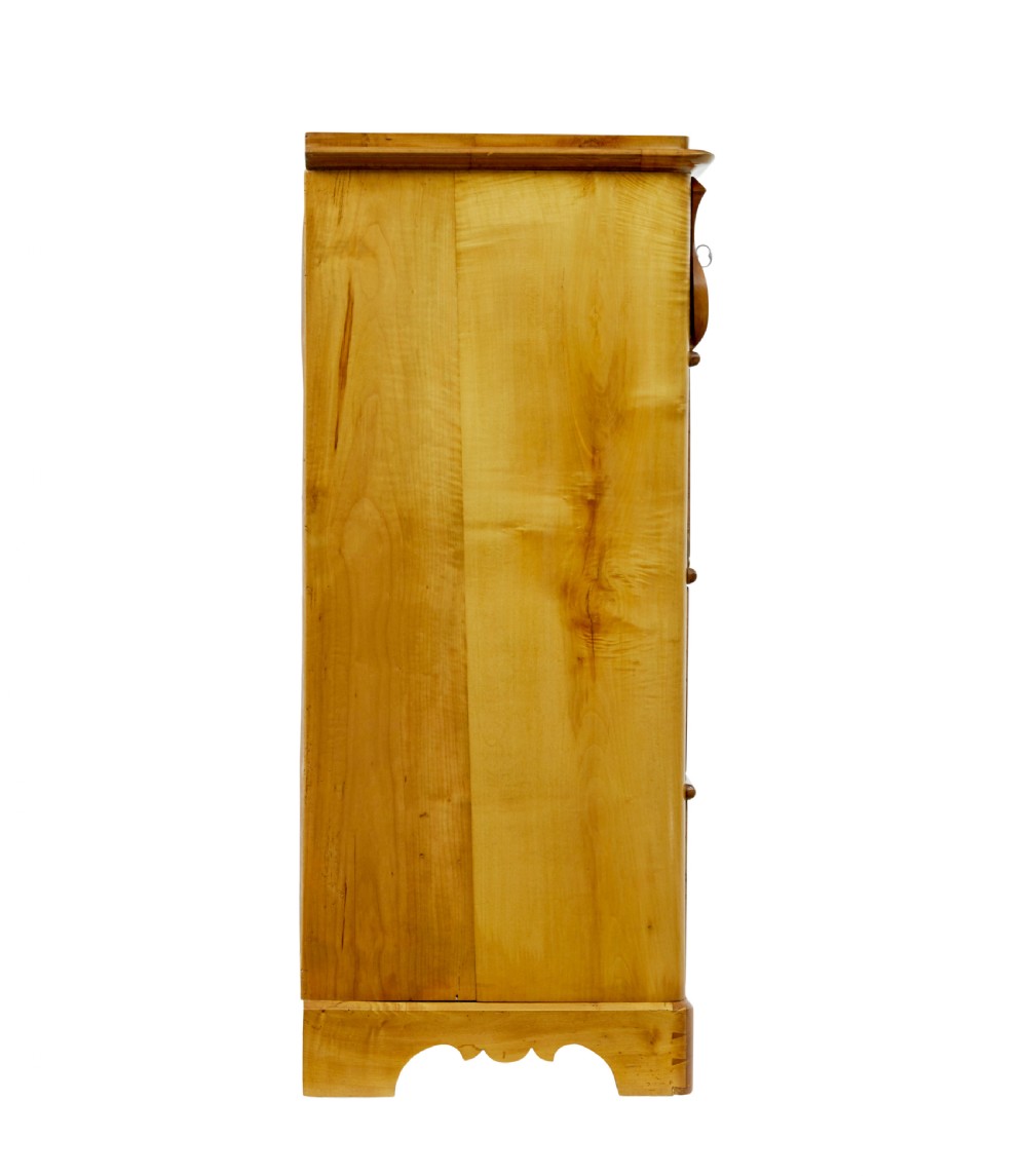 A 19th-century Swedish chest of drawers constructed from honey-toned flame birch with four drawers, keyhole escutcheons, and a scalloped base apron. View IX
