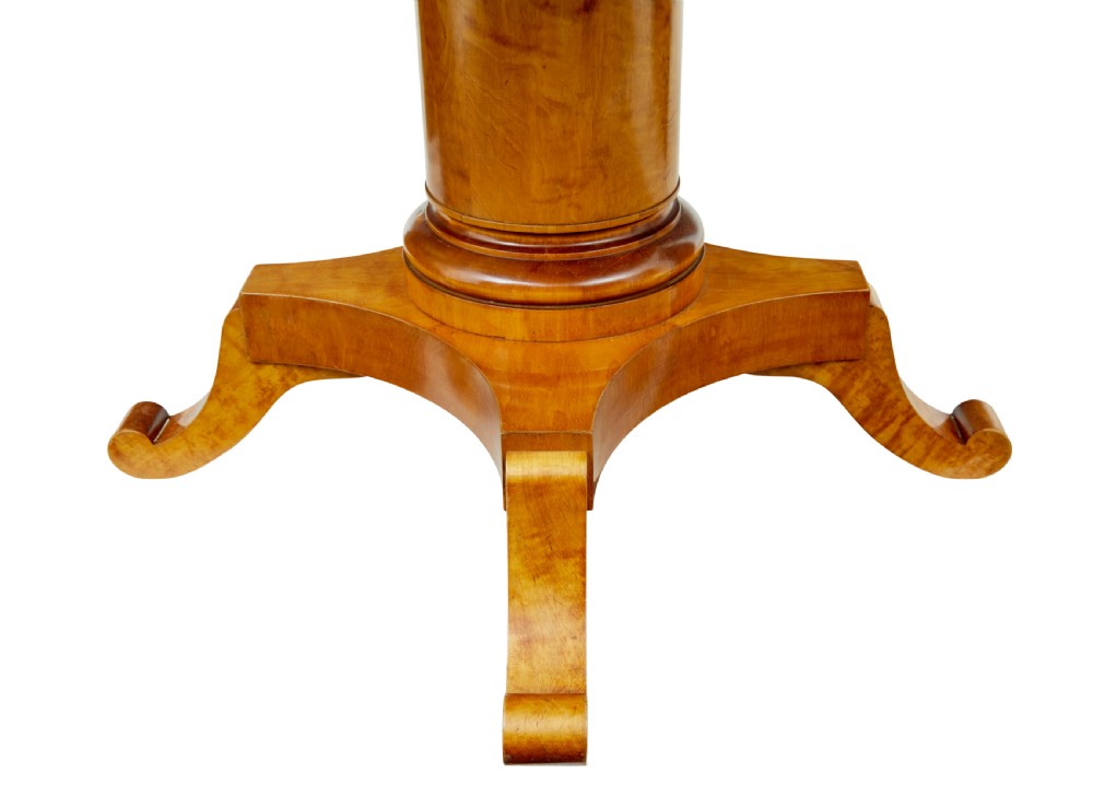 A late 19th-century Swedish circular centre table in golden satin birch veneer, featuring ebonised inlay, a cylindrical pedestal column, and a four-point plinth with scroll feet. View VIII