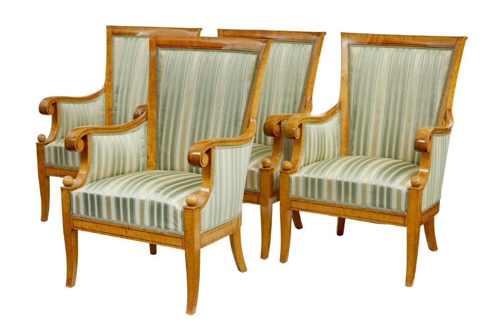 A set of four early 20th-century Karl Johan style birch armchairs featuring scroll arms and green striped upholstery.