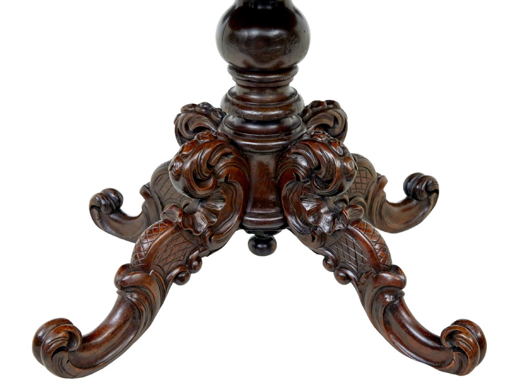 A 19th-century oval wood centre table featuring a flame mahogany veneered top, beaded apron moulding, turned central column, and carved scroll feet. View II