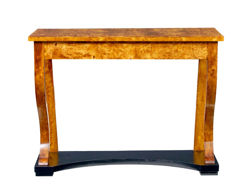 A nineteenth-century Empire Revival console table crafted from figured burr birch with curved leg supports and an ebonised plinth base.
