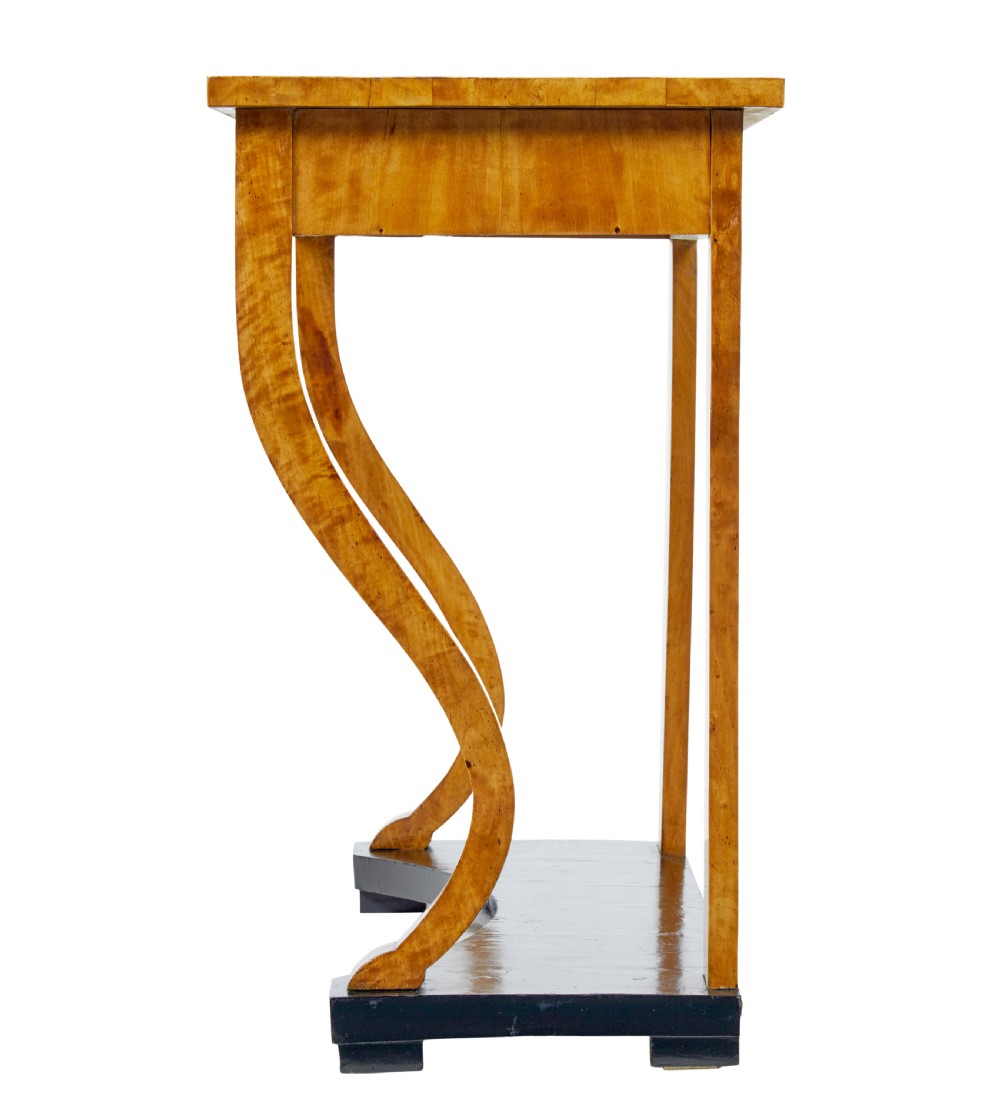 A nineteenth-century Empire Revival console table crafted from figured burr birch with curved leg supports and an ebonised plinth base. View II