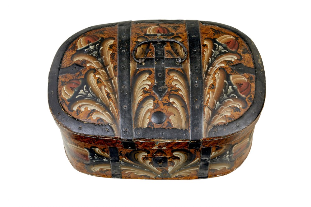 A 19th-century oval Scandinavian wooden box painted in warm ochre with dark floral scrollwork and fitted with black iron banding. View II