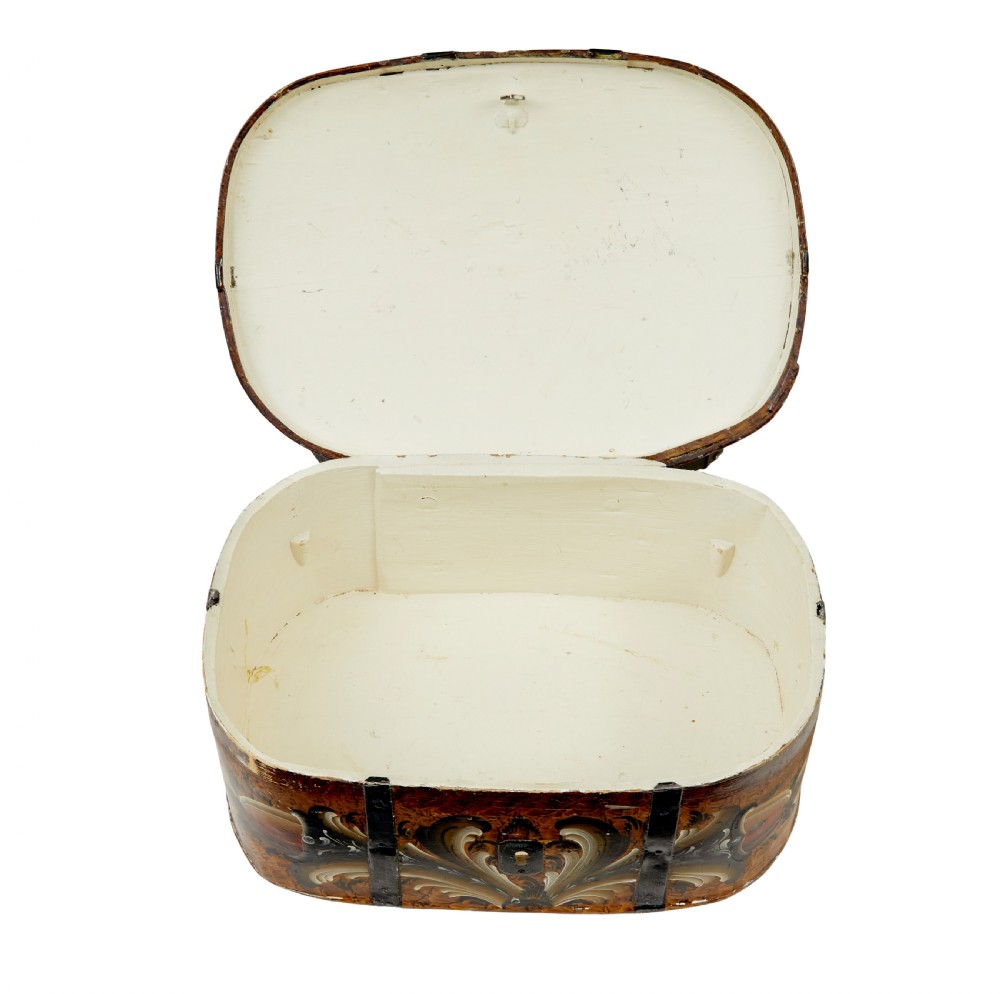 A 19th-century oval Scandinavian wooden box painted in warm ochre with dark floral scrollwork and fitted with black iron banding. View III