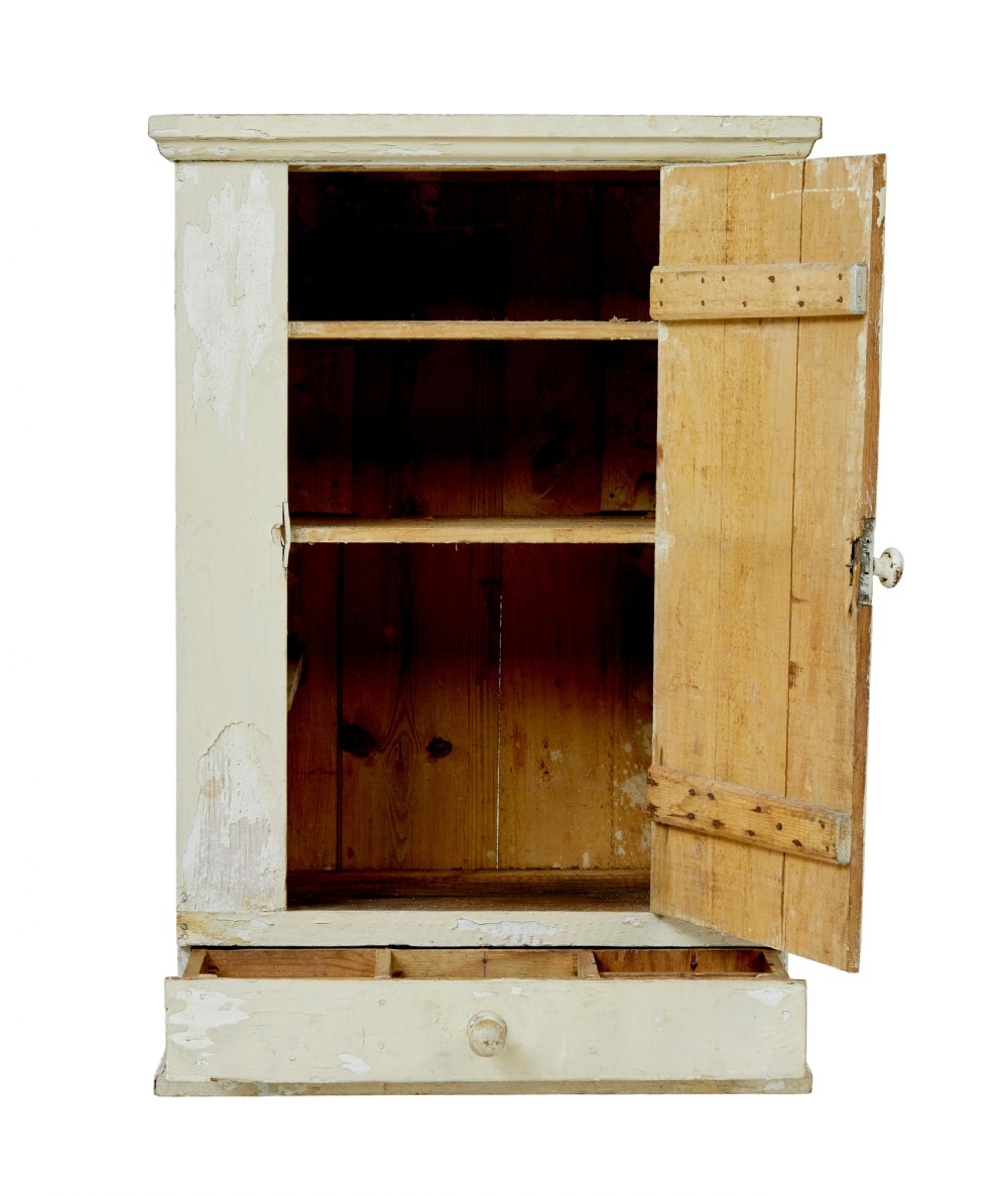 A 19th-century Scandinavian pine wall cupboard with a distressed cream painted finish, a single panelled door, and one lower drawer. View IV