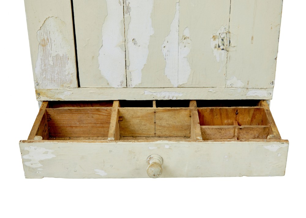 A 19th-century Scandinavian pine wall cupboard with a distressed cream painted finish, a single panelled door, and one lower drawer. View VIII