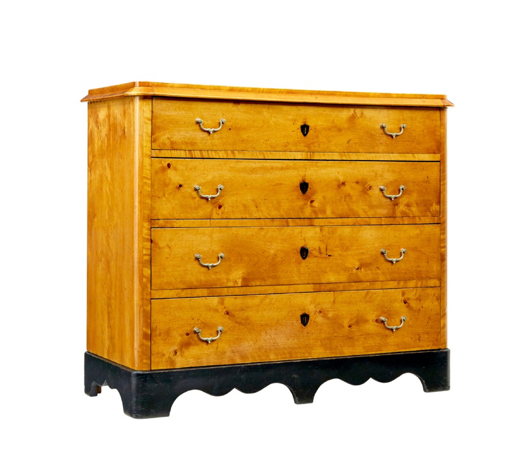 A 19th-century Swedish Empire Revival birch chest of drawers featuring four graduated drawers with metal handles, keyhole escutcheons, and a dark ebonised plinth base.