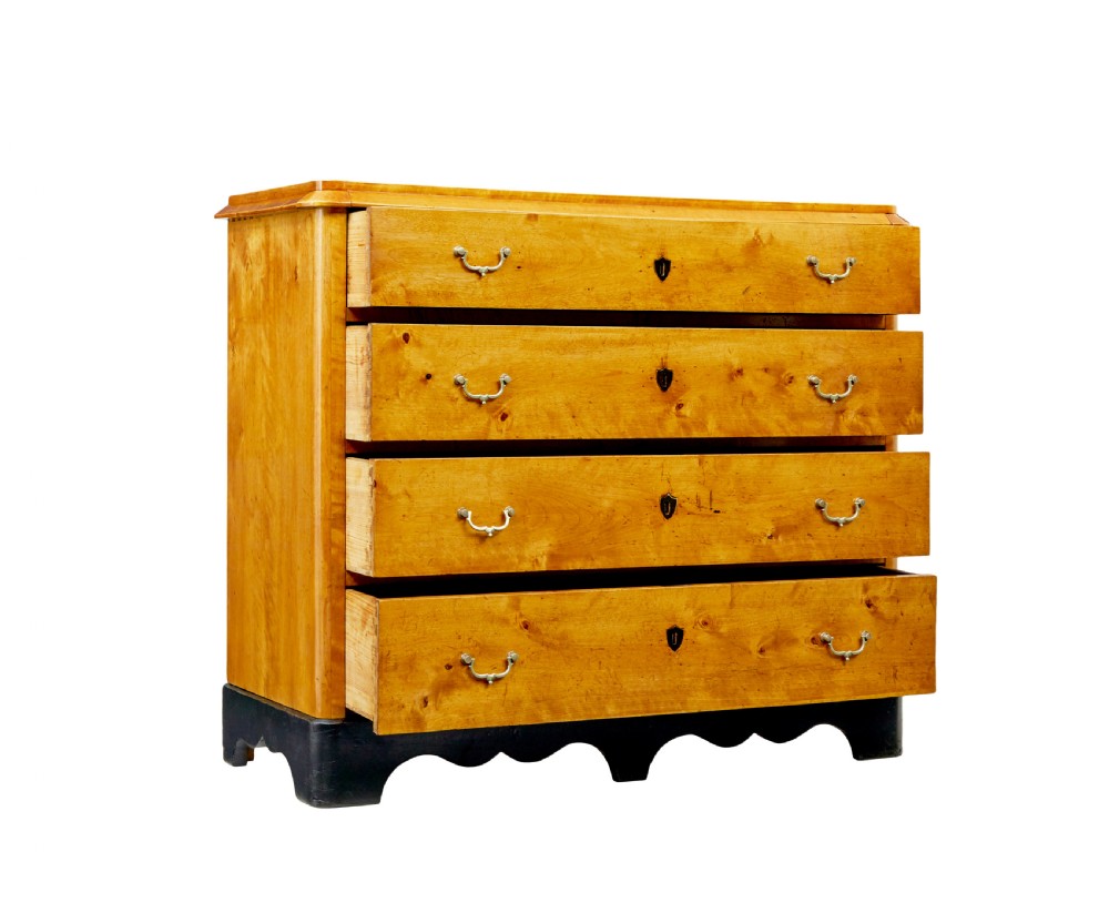 A 19th-century Swedish Empire Revival birch chest of drawers featuring four graduated drawers with metal handles, keyhole escutcheons, and a dark ebonised plinth base. View II