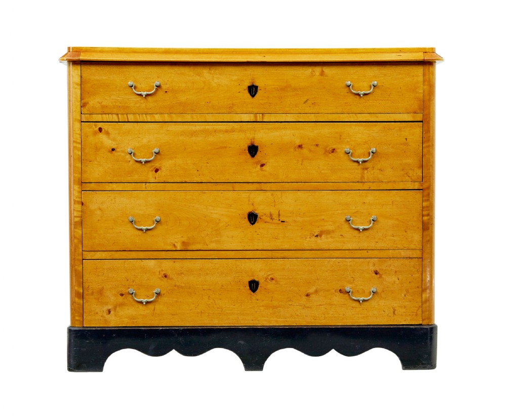 A 19th-century Swedish Empire Revival birch chest of drawers featuring four graduated drawers with metal handles, keyhole escutcheons, and a dark ebonised plinth base. View III