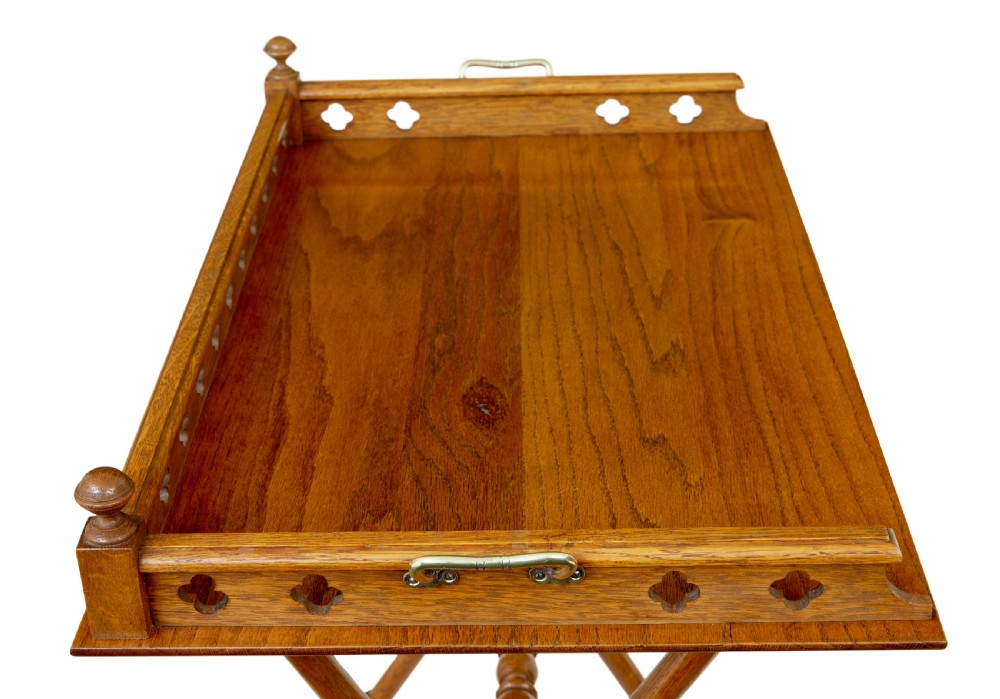 A 19th-century oak butlers tray featuring a trefoil pierced gallery border and brass handles resting on a folding X-frame stand. View II