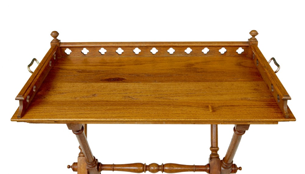A 19th-century oak butlers tray featuring a trefoil pierced gallery border and brass handles resting on a folding X-frame stand. View III