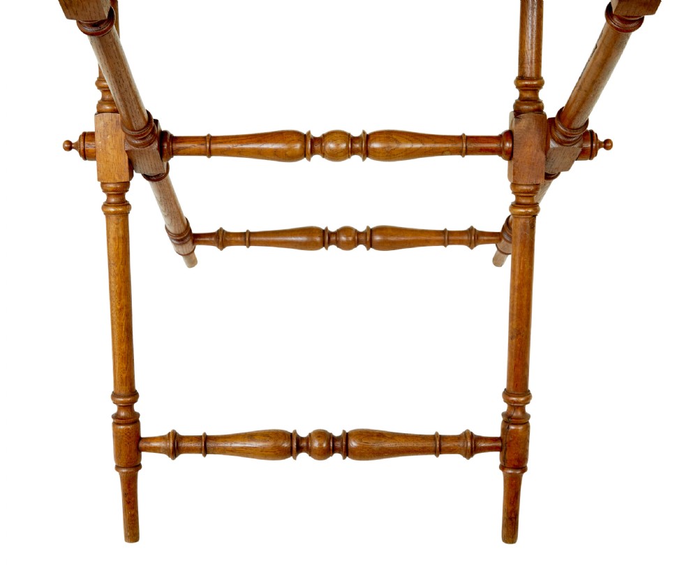A 19th-century oak butlers tray featuring a trefoil pierced gallery border and brass handles resting on a folding X-frame stand. View IV