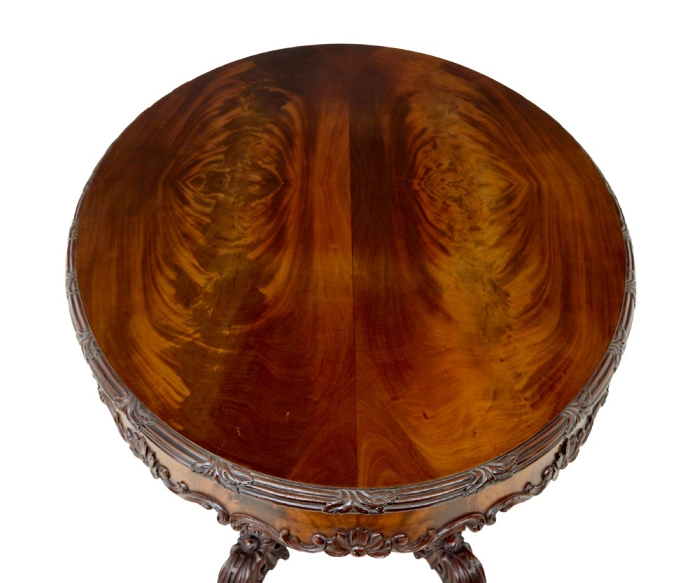 An antique 19th-century oval mahogany centre table featuring a carved apron, a central turned pedestal stem, and a carved four-legged base with scroll feet. View III