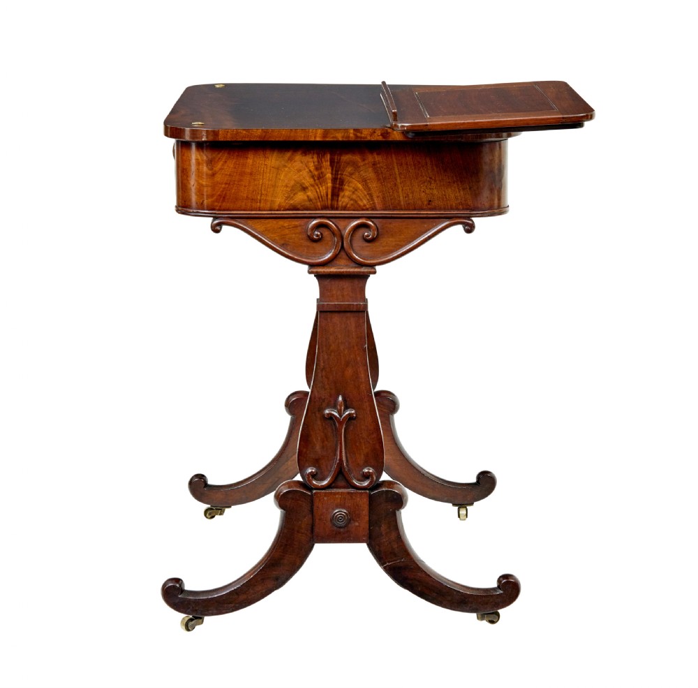 A mid-19th century dark mahogany writing table featuring an adjustable reading slope on top, a single open frieze drawer, scrolled side supports, turned stretcher, and brass castors. View III