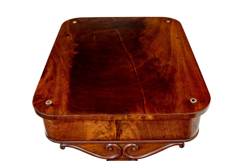 A mid-19th century dark mahogany writing table featuring an adjustable reading slope on top, a single open frieze drawer, scrolled side supports, turned stretcher, and brass castors. View VIII
