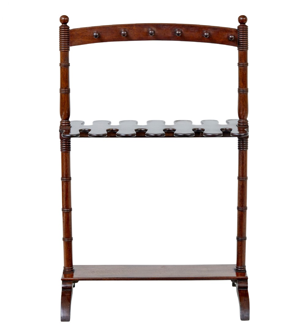 A mid-nineteenth-century dark mahogany wooden riding boot stand featuring turned side supports, upper hanging pegs, a notched central rack, and splayed feet. View VI